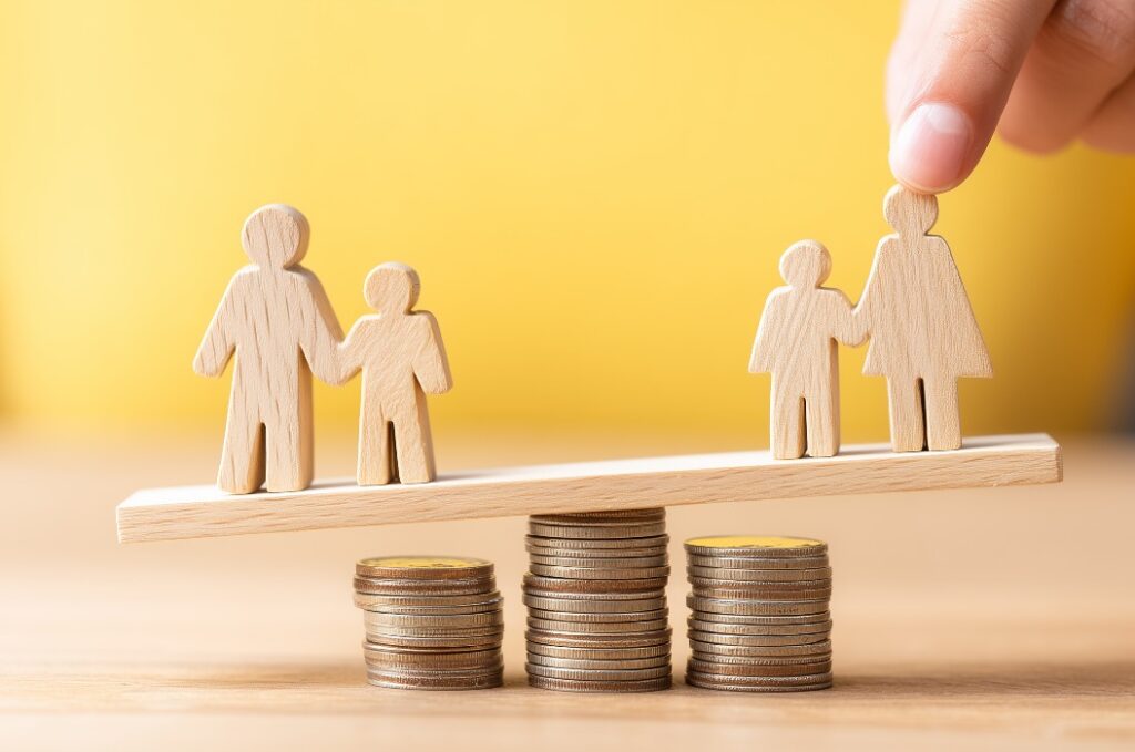 Family figures balancing on stacks of coins represent fair budget allocation and shared responsibility between households, conveying financial planning and equitable support.
