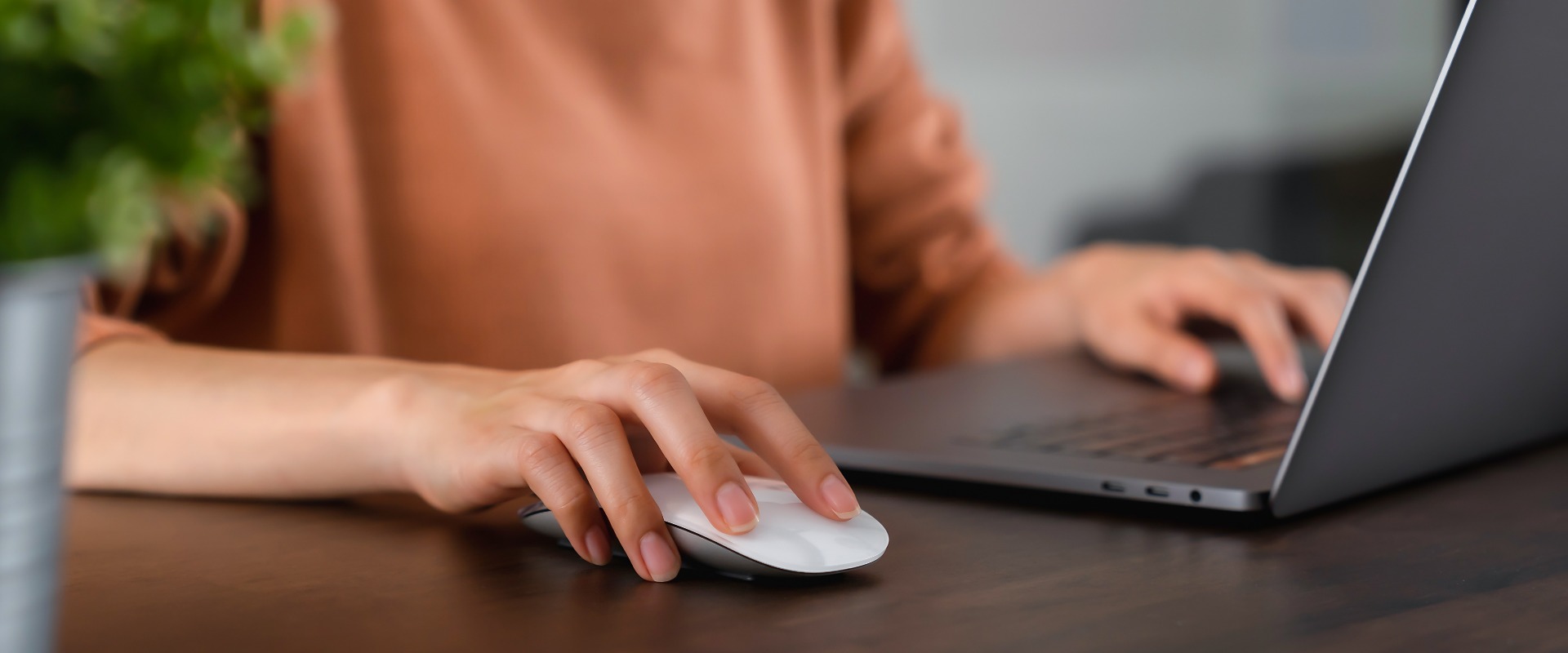 Nahaufnahme von Hand drücken Sie die Taste Computer-Maus und mit Laptop auf dem Tisch.