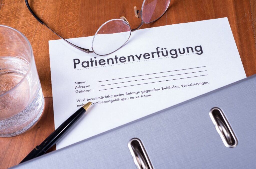 Patientenverfügung mit Ordner Brille und Füller