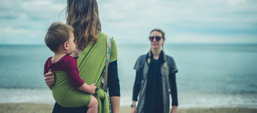 Two young women with a baby on the beach